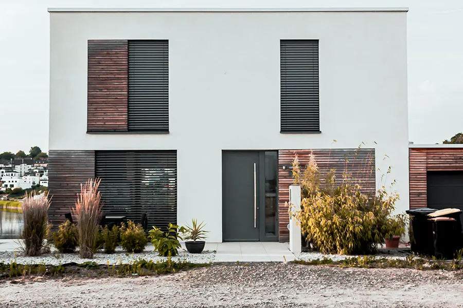 Einfamilienhaus mit frisch gestrichener weißer Putzfassade und dunklem Dach