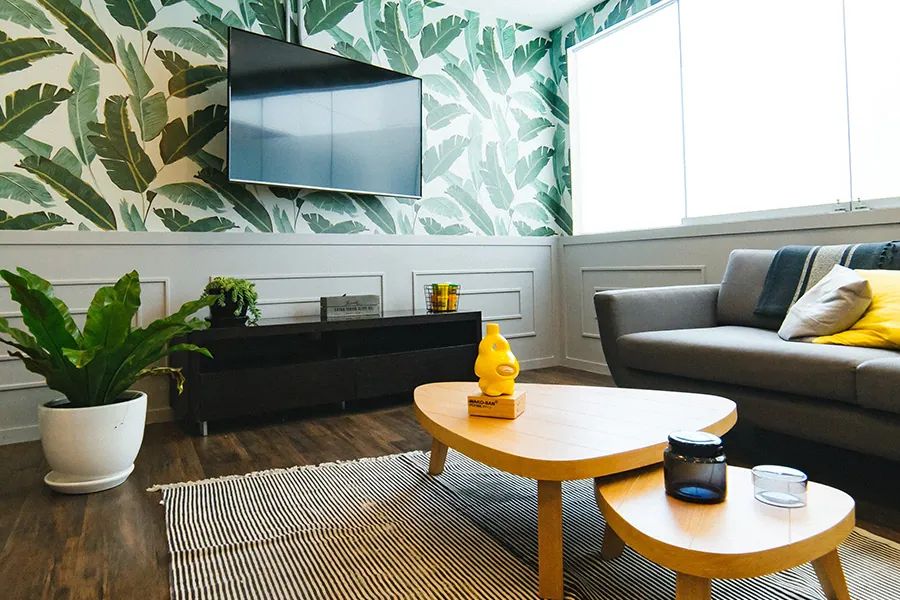 Wohnzimmer mit grüner Mustertapete und grauem Sofa, Wandgestaltung in Mülheim an der Ruhr