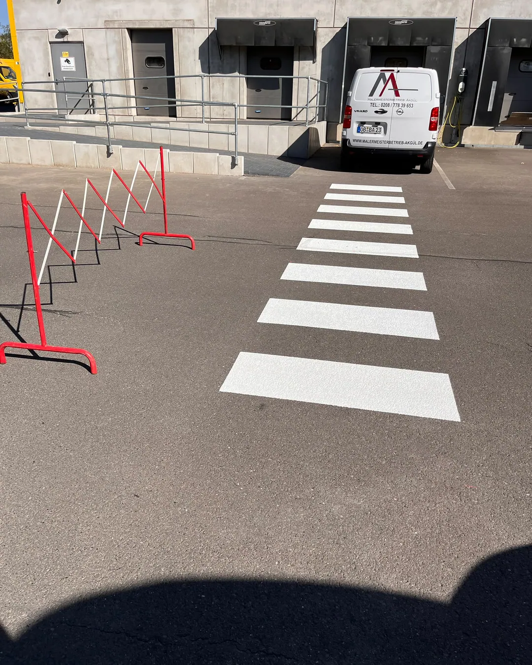 Frisch markierter Fußgängerüberweg mit weißen Streifen auf einem Parkplatz